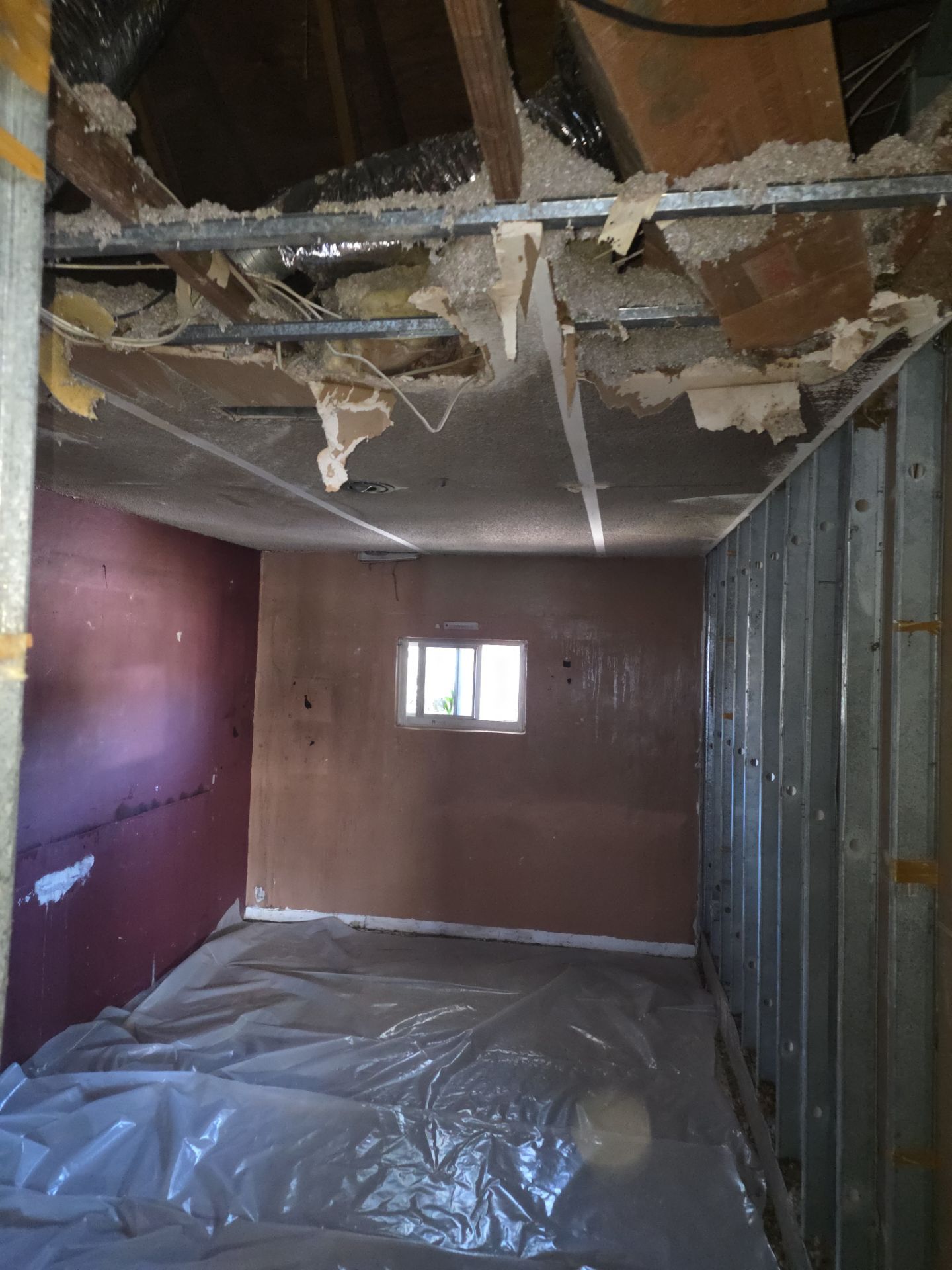 Fire-damaged room with collapsed ceiling and exposed framing